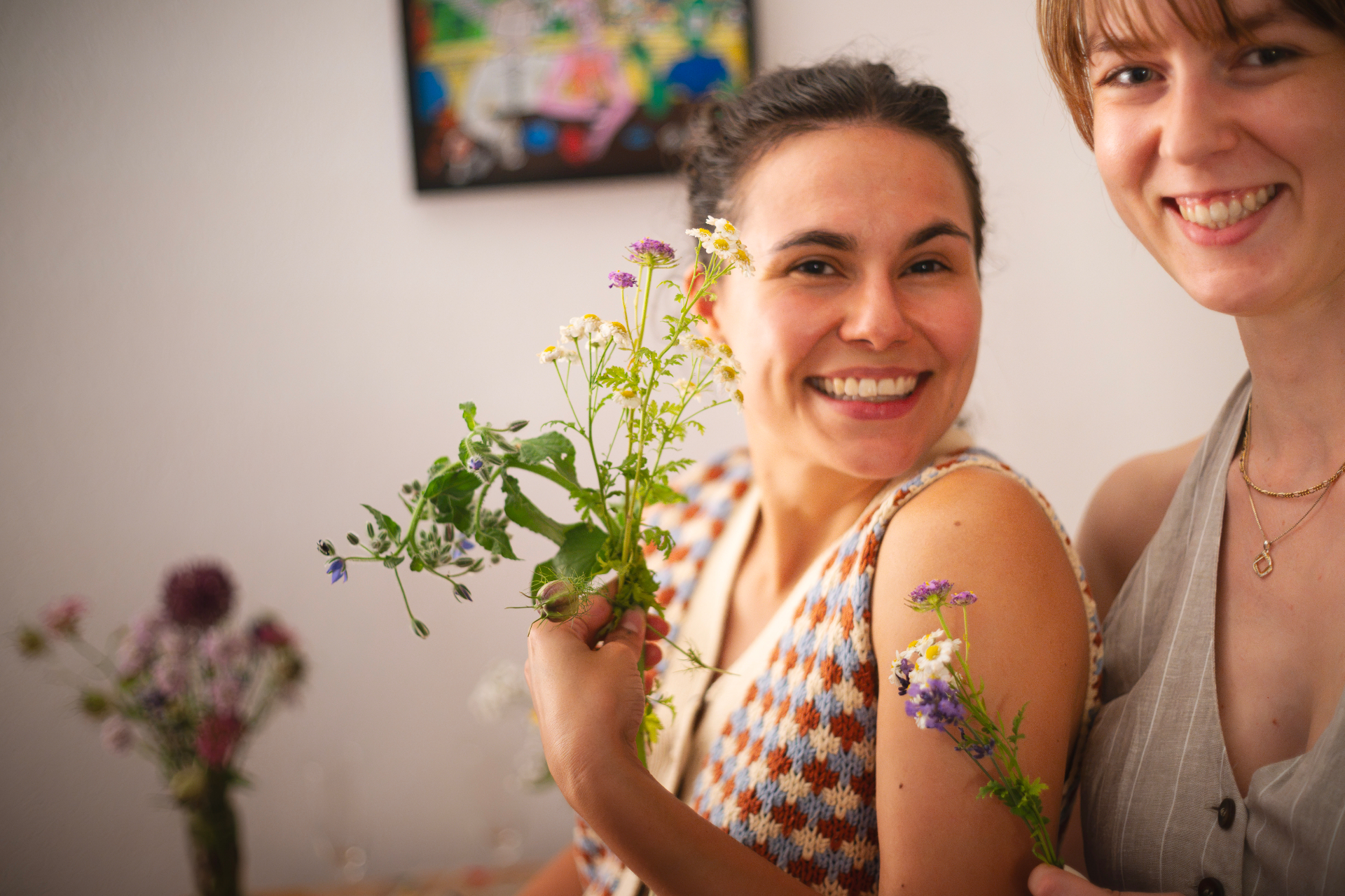 Two guests smiling with a hand-tied bouquet of chamomile, borage and verbena at the Zurich Seefeld Session