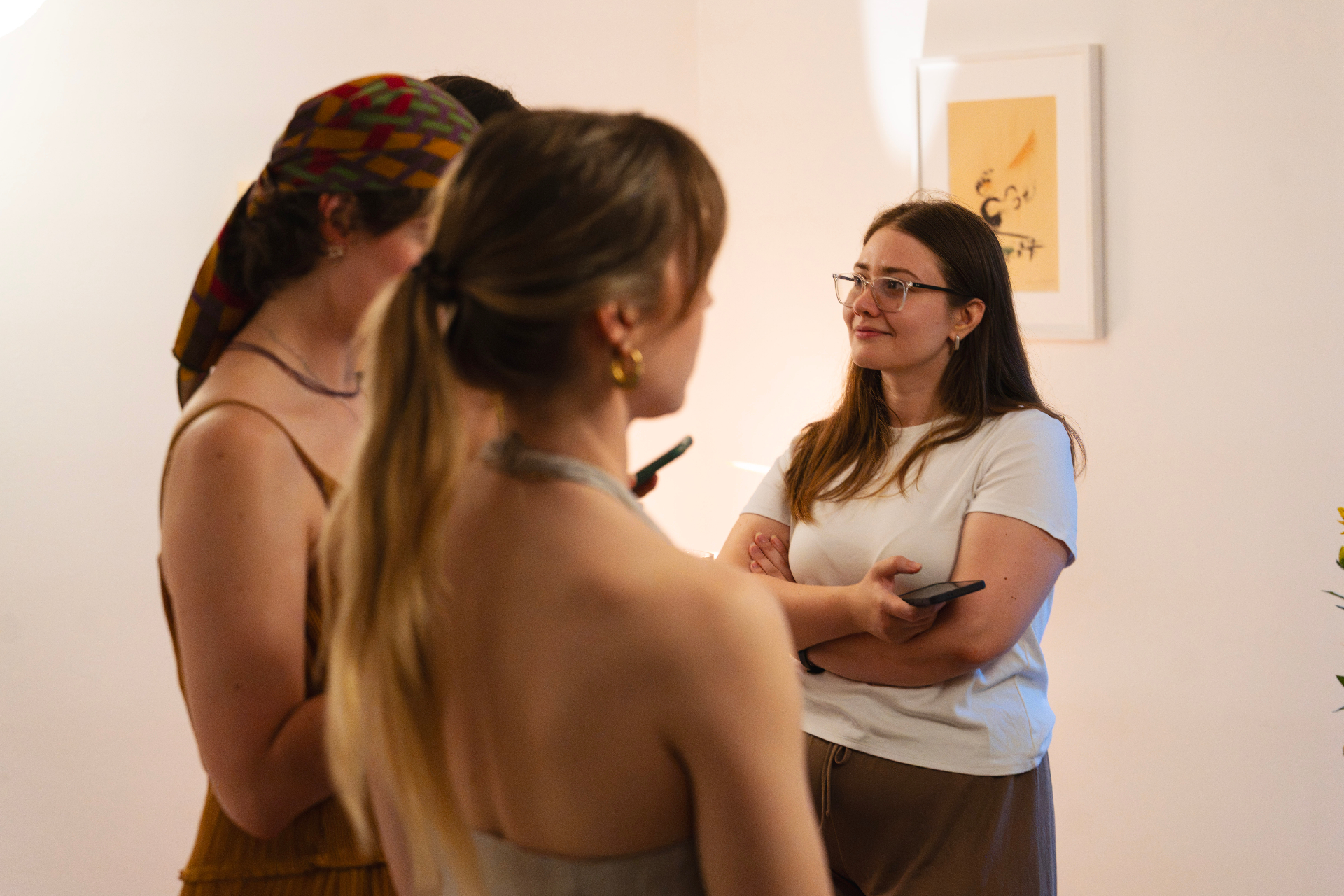 Three guests in conversation beside a framed artwork at the Zurich Seefeld Session