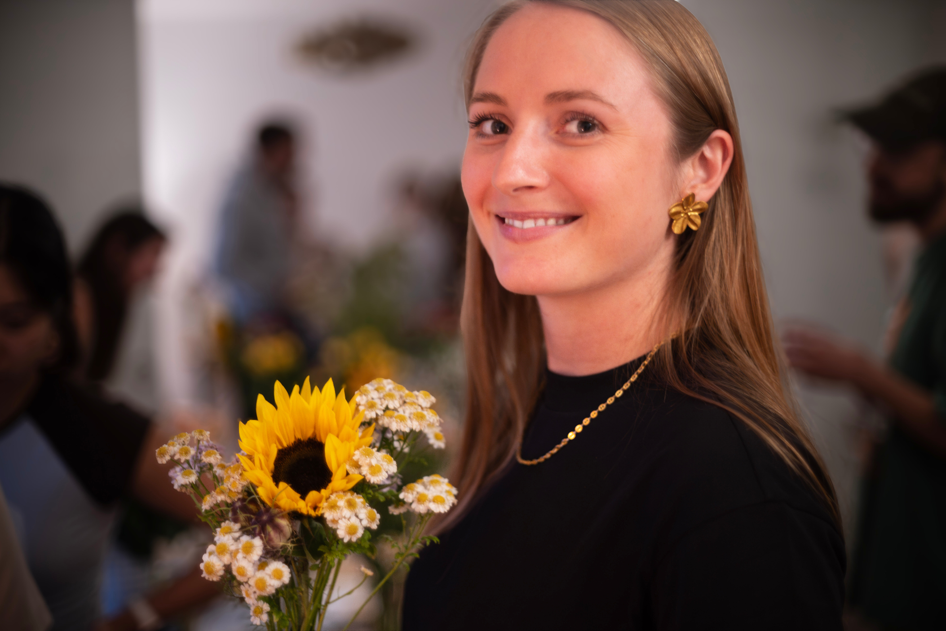 Guest with sunflower bouquet and gold floral earrings at the Zurich Seefeld Session